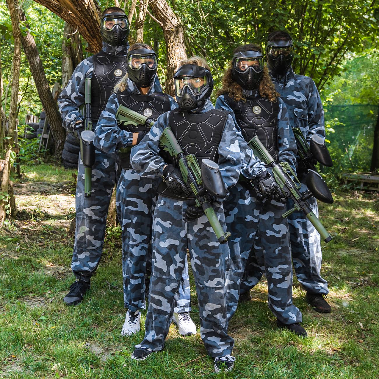 Skupina igrača u sivim kamuflažnim kombinezonima s paintball opremom